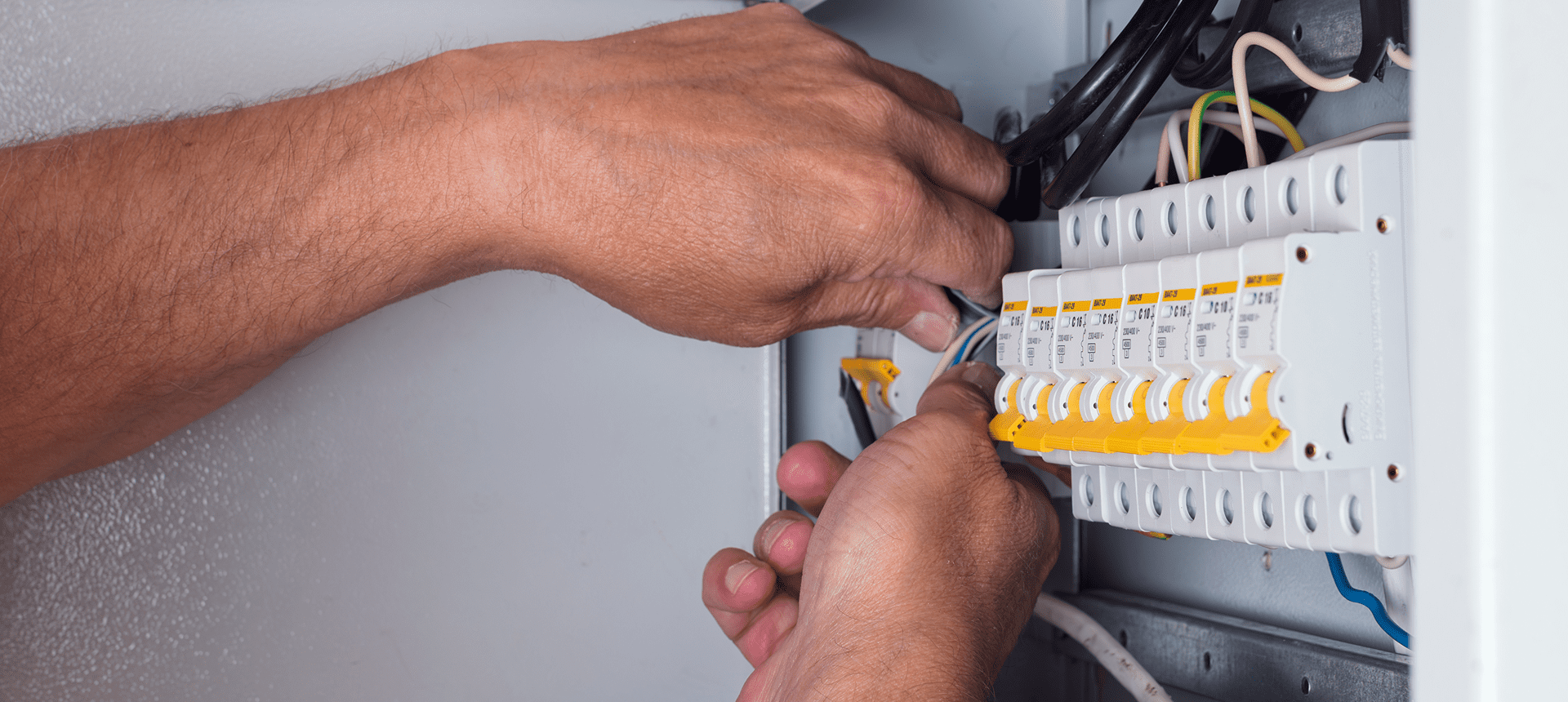 Hands adjusting electrical circuit breakers