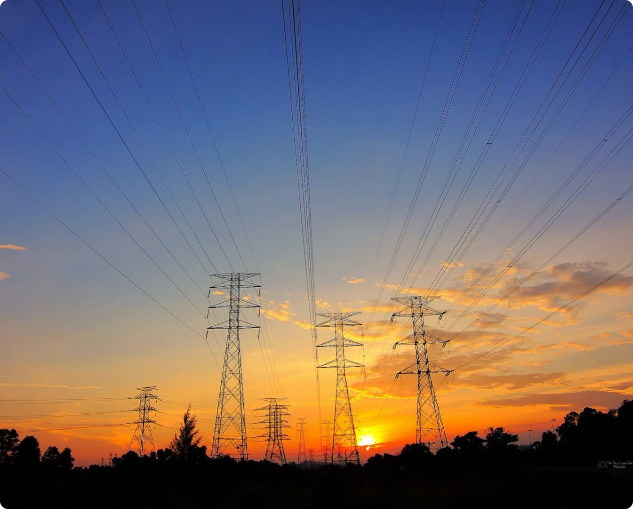 Transmission towers against colorful sky