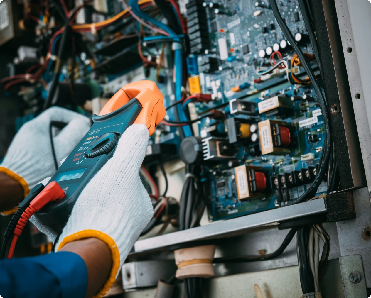 Electrical technician using tools on circuit board