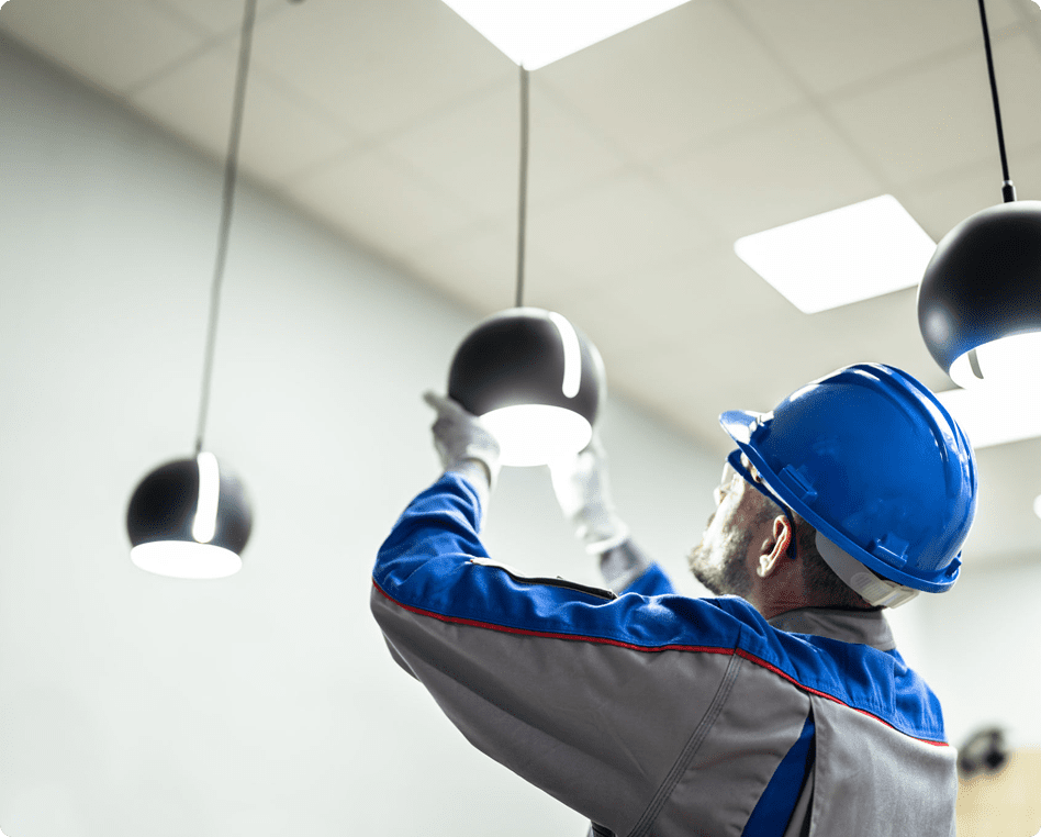 Technician maintaining overhead light installation